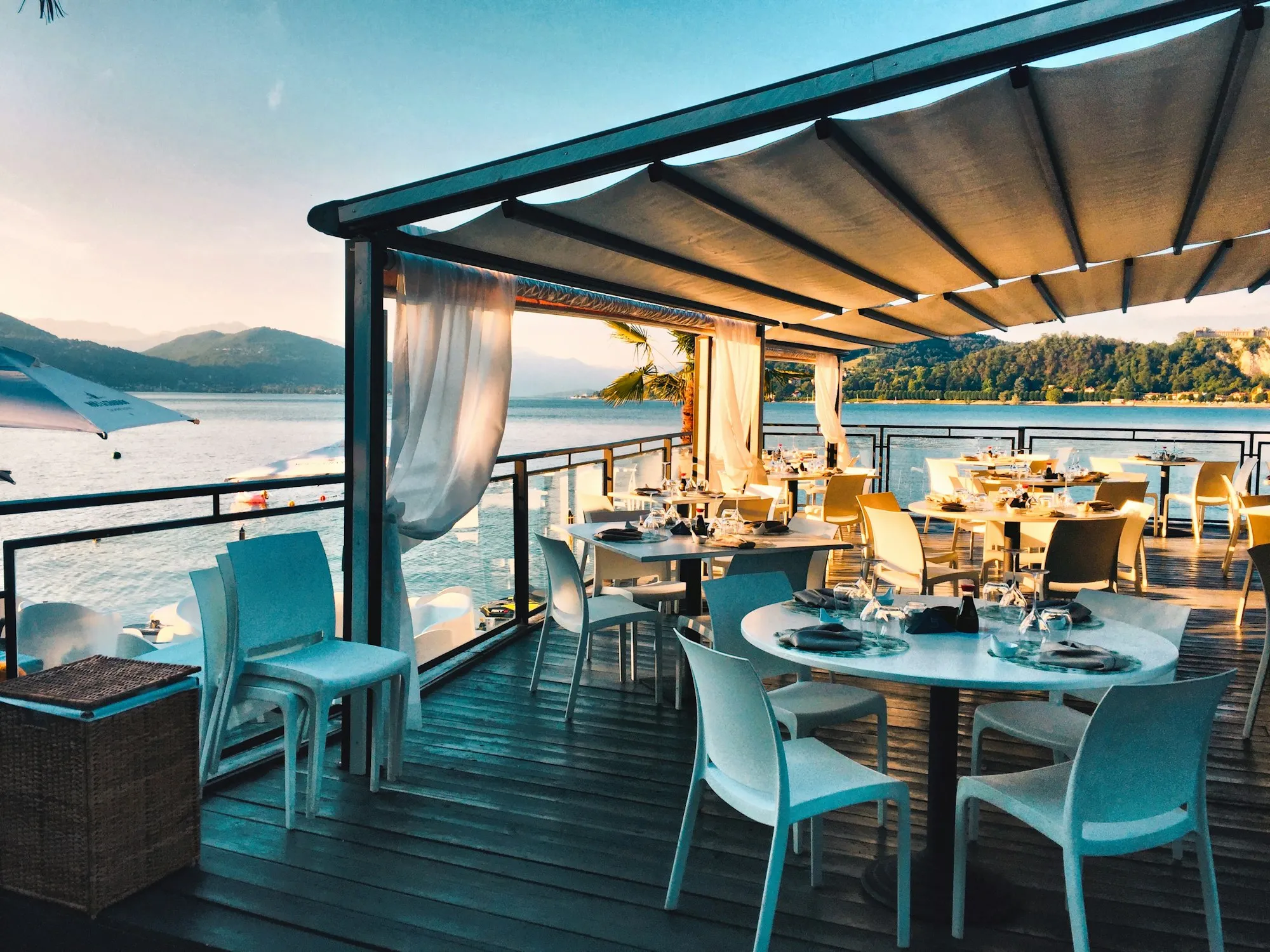 Tables on a covered terrace above the sea
